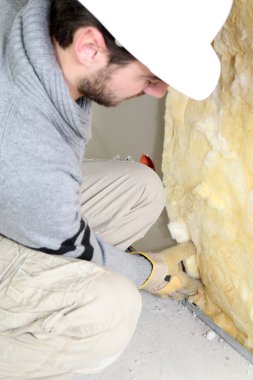Wall insulation being installed by builder clipart