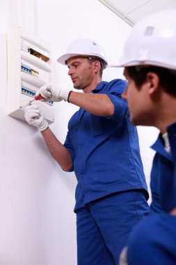 Tradesman repairing a distribution board clipart