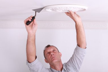 Plasterer working on ceiling motif clipart