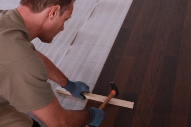 Handyman laying floorboards clipart