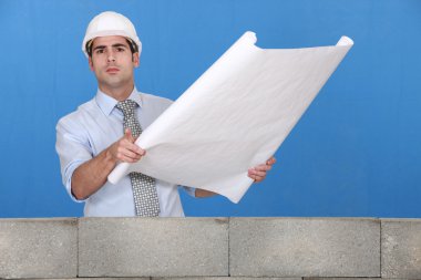 Engineer unrolling a technical drawing clipart