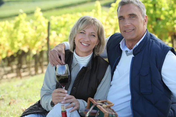 Couple tasting wine in a vineyard — Stok fotoğraf