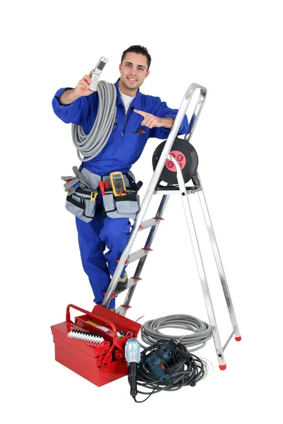 Manliga elektriker omgiven av utrustning — Stockfoto