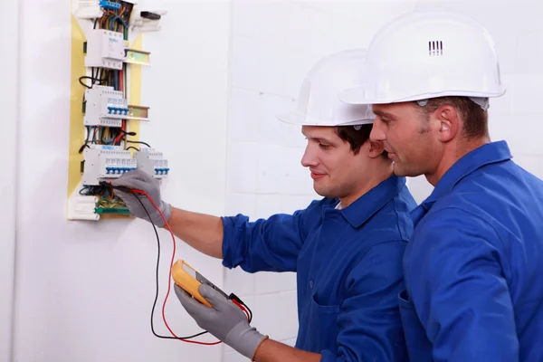Dos electricistas realizando comprobaciones — Foto de Stock