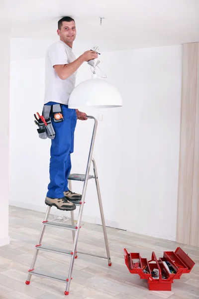 Handyman fixação de iluminação — Fotografia de Stock