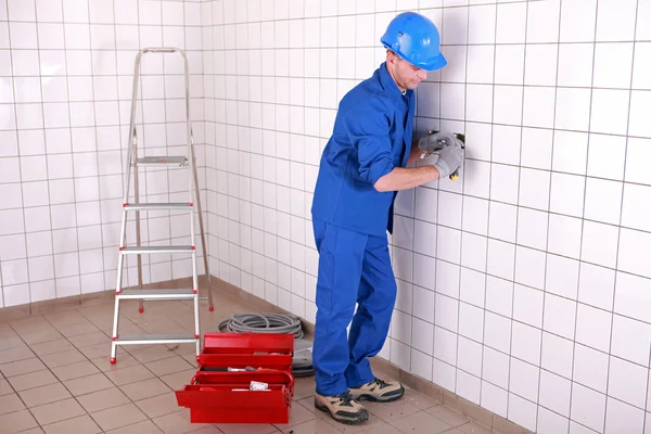 Eletricista fiação de uma grande sala de azulejos — Fotografia de Stock