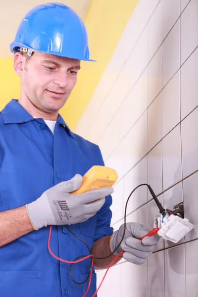 Electrician is checking an outlet with an ammeter — Stock Photo, Image