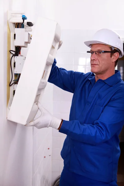 Homem inspecionando caixa de fusíveis — Fotografia de Stock