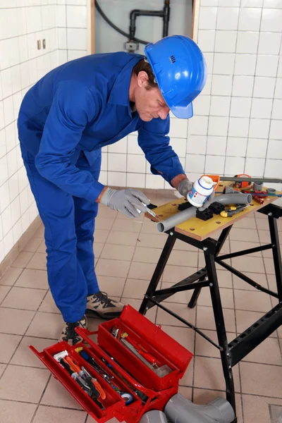 Plombier expérimenté au travail avec divers outils — Photo