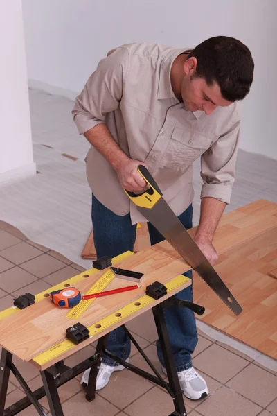 Handyman cutting a board — Stock Photo, Image