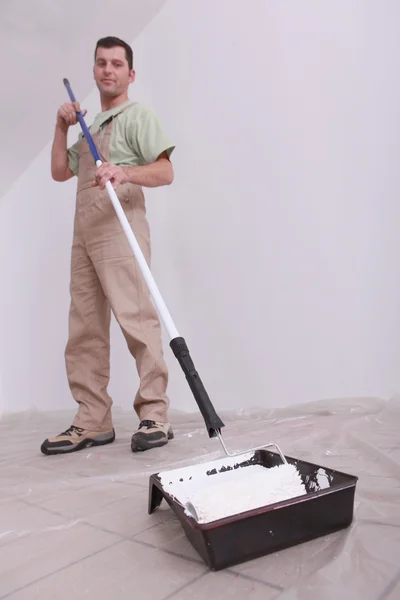 Werknemer schilderen met een roller — Stockfoto