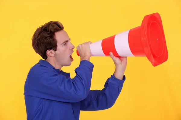 Young blue collar shouting in construction cone — Stock Photo, Image