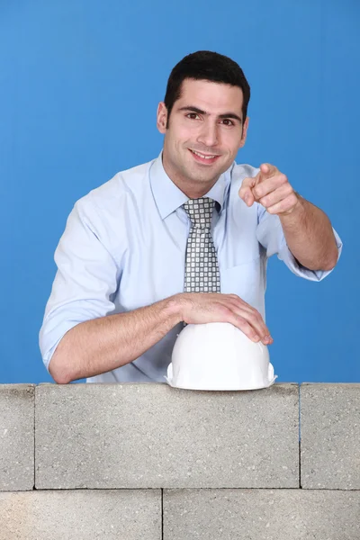 Architect stood by wall pointing — Stock Photo, Image