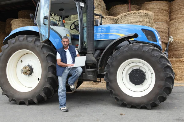 Farmář s notebookem na traktor — Stock fotografie