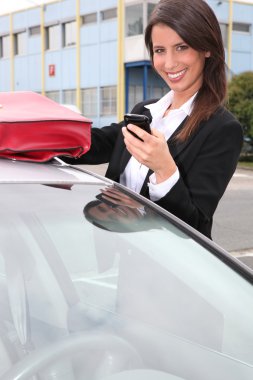 Woman with a phone by her car clipart
