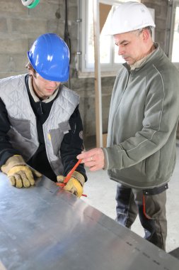 Construction workers using a tool clipart