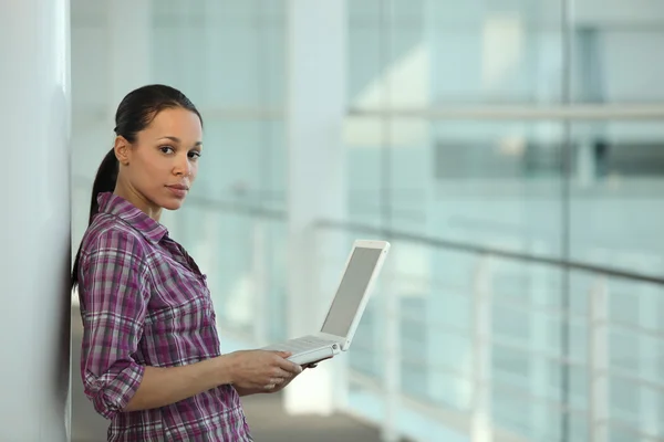 Egy nő használja a laptopját a folyosón. — Stock Fotó
