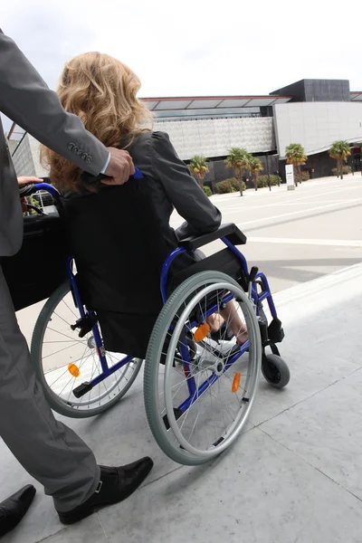 Female executive being pushed in wheelchair — Stock Photo, Image