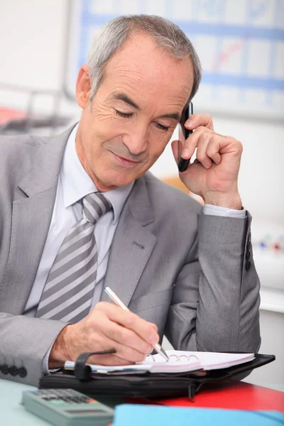 Senior zakenman met cellphone — Stockfoto