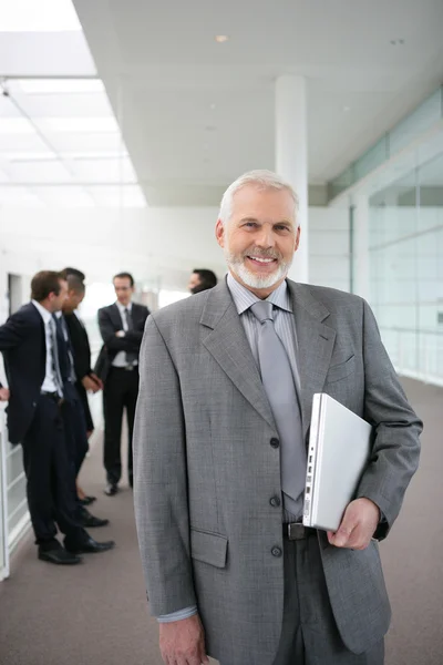 Homme d'affaires supérieur debout dans un couloir — Photo