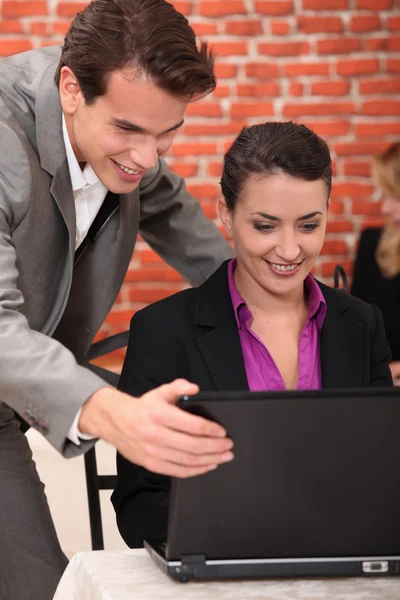 Young businesspeople looking at a laptop — Stock Photo, Image