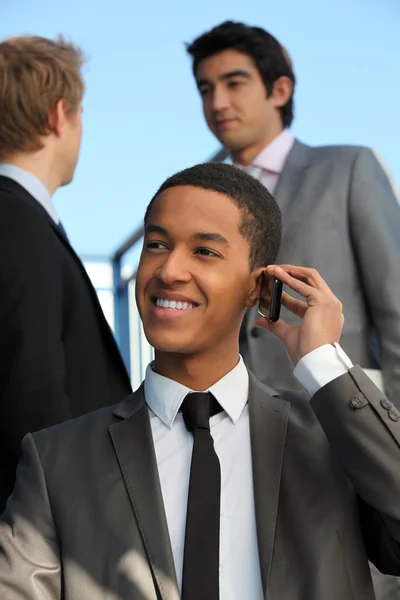 Ung affärsman talar på hans mobiltelefon — Stockfoto