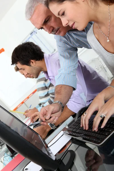 Μαθητές και δάσκαλος που εργάζονται με το φορητό υπολογιστή στο κολέγιο — Φωτογραφία Αρχείου