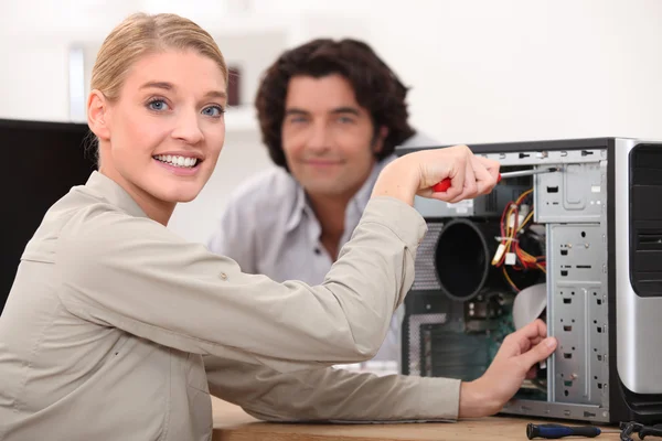 Glücklicher Techniker, der einen Computer repariert — Stockfoto