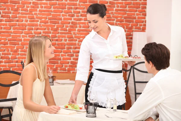 Casal interagindo com garçonete em um jantar — Fotografia de Stock