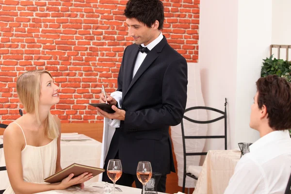 Una pareja elegante pidiendo en un restaurante chic —  Fotos de Stock