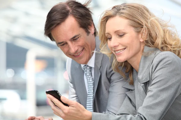 Businessman and woman with phone — Stock Photo, Image