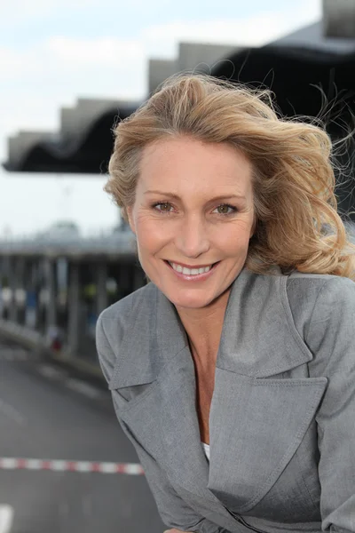 Geschäftsfrau lächelt mit Wind im Haar — Stockfoto