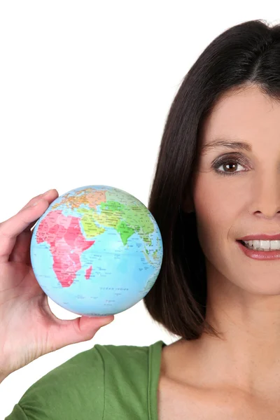 Young woman taking a little globe in her hand — Stock Photo, Image
