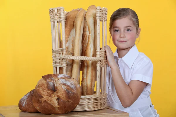 Liten flicka klädd som arbetstagare i bageri — Stockfoto