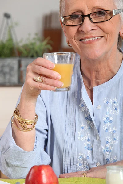 Portakal suyu sahip üst düzey kadın — Stok fotoğraf