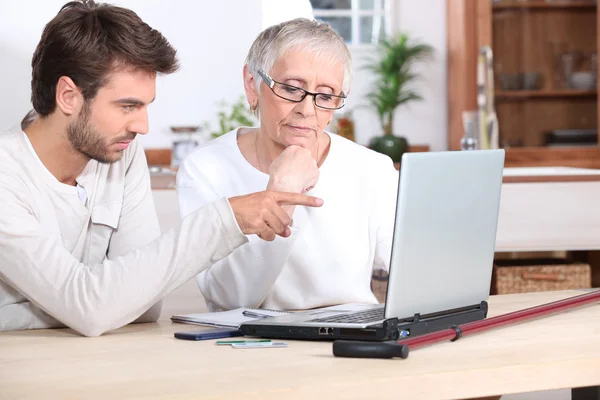 Son helping Mother on laptop — Stock Photo, Image