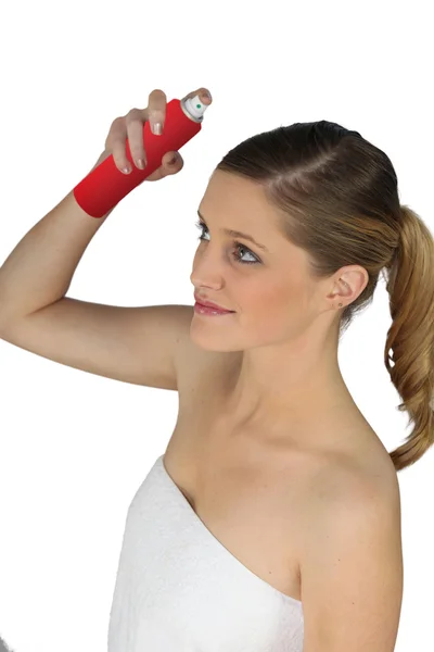 Mulher jovem usando spray de cabelo — Fotografia de Stock