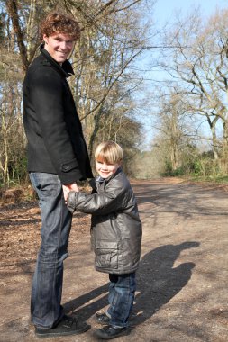 Father and son taking a walk in the woods clipart