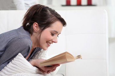 Woman reading at home clipart