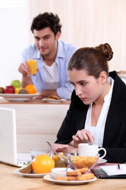 Career woman eating breakfast while working clipart