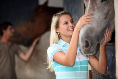 Man and woman cuddling a horse clipart