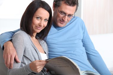 Mature couple skimming through catalogue clipart