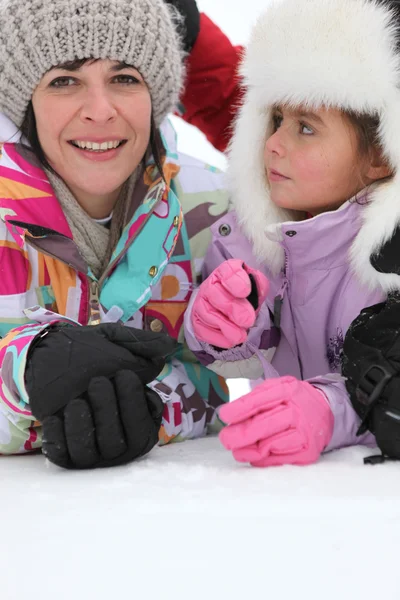 Mor och dotter leker i snön — Stockfoto