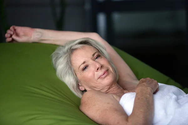 Oudere vrouw liggend in bed — Stockfoto