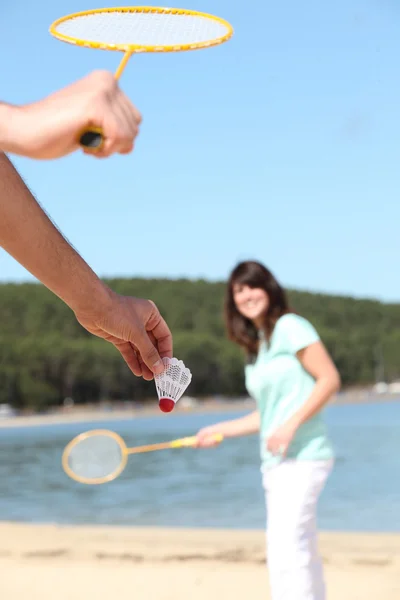 Homem e mulher jogando badminton na praia — Fotografia de Stock