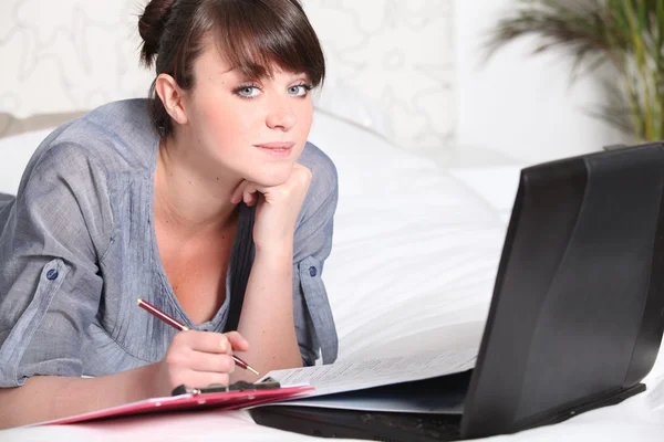 Ung kvinna som arbetar på en bärbar dator hemma — Stockfoto