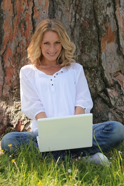 Γυναίκα σε φορητό υπολογιστή, κάτω από το δέντρο — Φωτογραφία Αρχείου