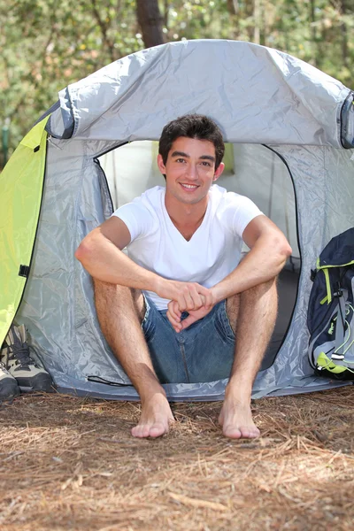Adolescente sentado na frente de sua tenda em um dia ensolarado — Fotografia de Stock