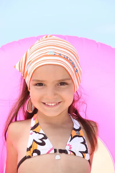 Petite fille à la plage avec anneau gonflable en caoutchouc — Photo