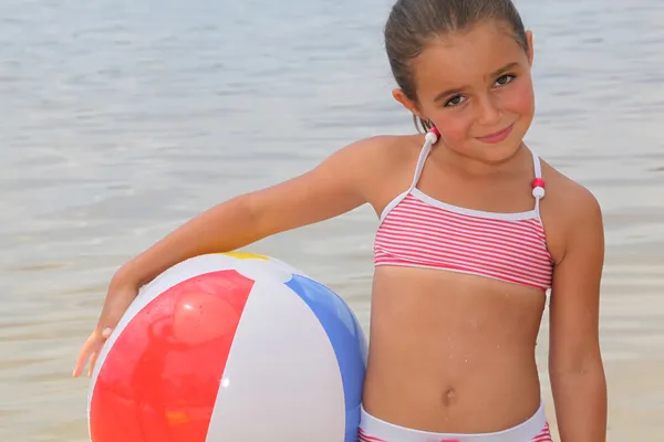 Menina segurando bola de praia — Fotografia de Stock